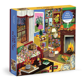 Enjoy a relaxing autumn getaway with Galison’s "Fall is in the Air" 500 Piece Jigsaw Puzzle, featuring a vibrant illustrated fall living room filled with cats, pumpkins, a fireplace, and charming seasonal décor.