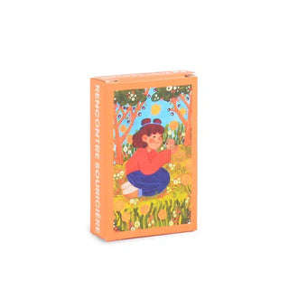 The Rencontre Souricière | 99 Piece Jigsaw Puzzle by Trevell comes in a small orange box featuring garden artwork with a kneeling figure, trees, and flowers, plus the title “Rencontre Souricière” on the side.