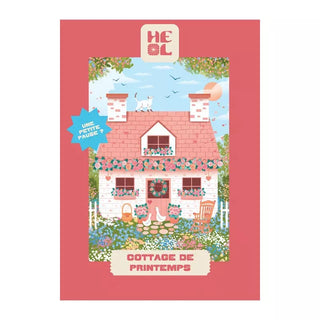 Delightful 99-piece jigsaw puzzle from Heol Editions: Spring Cottage shows a pink cottage with flowers, a white cat on the roof, blue sky, and “COTTAGE DE PRINTEMPS” text. Speech bubble reads “UNE PETITE PAUSE?” Made in France.