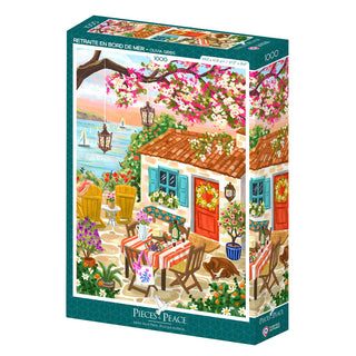 Retraite en Bord de Mer is a 1,000-piece jigsaw puzzle by Pieces & Peace, featuring Olivia Gibbs’ seaside cottage scene with garden, flowers, dining table, and sailboats. Made in France.