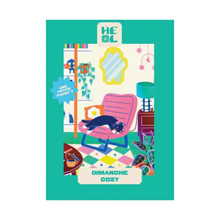 The Dimanche Cozy | 99 Piece Jigsaw Puzzle by Heol Editions features a black and white cat napping on a pink chair in a vibrant, plant-filled room. "DIMANCHE COZY" appears at the bottom. Made in France.