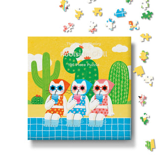 The cover of The Puzzle Theory’s “Poolside Chill” 196-piece jigsaw puzzle features three playful cartoon dogs in swimsuits and sunglasses relaxing by a pool, surrounded by cacti. Loose pieces scattered around the box add to the fun, making this vibrant summer puzzle perfect for anyone who enjoys cheerful, sun-filled scenes.
