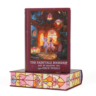 The Fairytale Bookshop | 250 Piece Jigsaw Puzzle by Kingdom of Threads, featuring artwork of two figures stepping into a whimsical indie bookshop, comes stacked on a decorative keepsake book box embellished with a stained glass design.