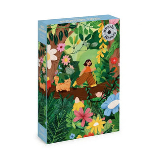 Duo Sauvage 500 Piece Jigsaw Puzzle by Trevell featuring an illustration of a person and a ginger cat walking on a large fallen tree trunk amidst colorful flowers and forest foliage.