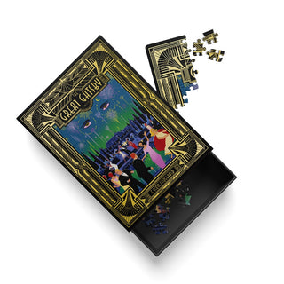 Introducing the Great Gatsby | 99 Piece Jigsaw Puzzle by Ohh Deer—an Andrew Kolb-inspired puzzle box showcasing a bold art deco cover design, with partially assembled pieces displayed and its lid slightly ajar, hinting at more hidden pieces within.