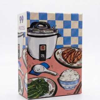 A matte-finish box from Arcadia Puzzles features the Sik Fan La | 99 Piece Jigsaw Puzzle, illustrated with a rice cooker, rice paddle, bowl of rice, vegetables, and sliced meat on a blue-and-white checkered background.