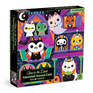 Mudpuppy’s Haunted House Cats | 500 Piece Jigsaw Puzzle features whimsical illustrations of cats dressed in Halloween costumes exploring a haunted house, and the box reads "Haunted House Cats | Glow in the Dark," making it the perfect glow-in-the-dark puzzle for some spooky season fun.