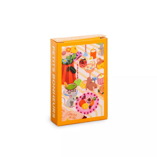 The Trevell Petits Bonheurs | 99 Piece Jigsaw Puzzle comes in an orange box with Anaïs Sanchez’s lively illustrations of food, drinks, and animals on a picnic table—a delightful mini puzzle for all ages.