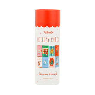 The Holiday Cheer | 500 Piece Jigsaw Puzzle from My Mind’s Eye comes in a tall, cylindrical container with a red lid and festive illustrations. The set includes a full-size poster to help you assemble the cheerful holiday scene.