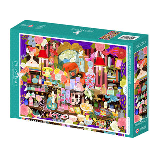 The Parfumerie Parisienne 2,000 Piece Jigsaw Puzzle by Pieces & Peace features Cynthia Frenette’s vibrant vanity table illustration, complete with perfume bottles and flowers. Made in France.