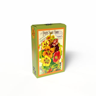 A green rectangular box with a vintage-style label features the Penny Puzzle Pansies Seeds | 99 Piece Jigsaw Puzzle—ideal for mini puzzle fans or anyone who loves a charming vintage seed bag theme.