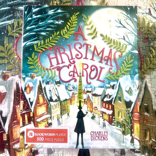 A Christmas Carol 500 Piece Jigsaw Puzzle box showing a snowy Victorian London street scene with a man in a top hat standing in the center.