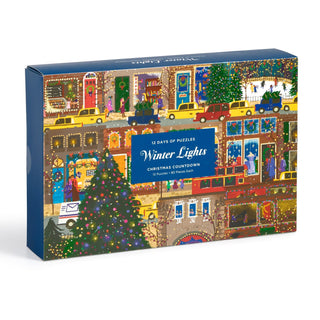 Galison’s Joy Laforme Winter Lights 12 Days of Puzzles Christmas Advent Puzzle Calendar features festive city buildings, Christmas trees, yellow taxis, and holiday decorations—perfect for puzzle fans or holiday countdowns.