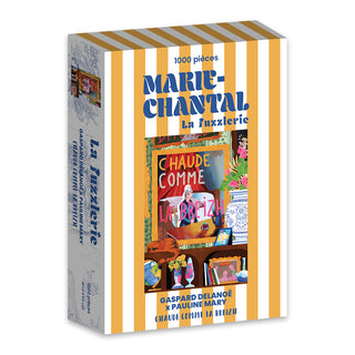 The Marie-Chantal Breizh 1,000 Piece Jigsaw Puzzle features a striped design, vibrant illustration, and “Chaud Comme La Breizh” sign, all with a luxurious velvet finish and proudly made in France.
