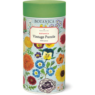 Packaged in a cylindrical container with a green lid, the Cavallini & Co. Botanica | 1,000 Piece Jigsaw Puzzle displays vibrant illustrated flowers on a light blue background.