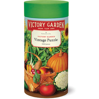 The Cavallini & Co. Victory Garden | 1,000 Piece Jigsaw Puzzle comes in a cylindrical container decorated with images of vegetables, a basket, and greenery.