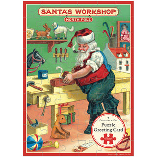 Santa Claus is hard at work at his bench in the North Pole, surrounded by toys and tools—a delightful scene illustrated on the Cavallini & Co. Christmas Santa’s Workshop | 60 Piece Greeting Card Jigsaw Puzzle. This charming holiday greeting card puzzle, labeled “Santa’s Workshop, North Pole,” is sure to bring festive cheer to any recipient.