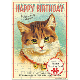 Celebrate with Cavallini & Co.'s Happy Birthday Cat 60 Piece Greeting Card Jigsaw Puzzle, featuring a vintage-style green-eyed cat with bell collar and "Happy Birthday" greeting—a unique and charming birthday surprise!.