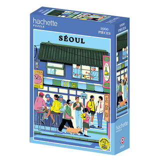 The Hachette Puzzle "Seoul" is a 1,000-piece jigsaw featuring a fagostudio street scene with people and a dog outside a building in Seoul, South Korea. Made in France.
