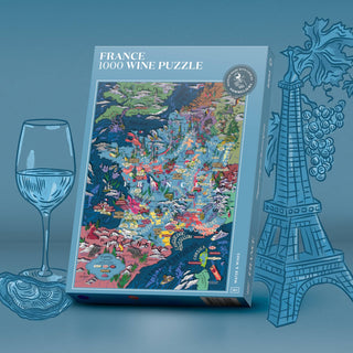 The France Wine | 1,000 Piece Jigsaw Puzzle by Water & Wines stands upright beside a wine glass, an oyster, and illustrated grape varieties and the Eiffel Tower, all on a blue background.