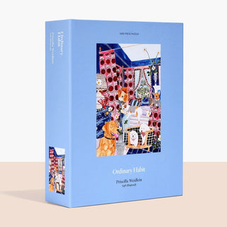 Blue box featuring Soft Rhapsody, a 1,000 piece jigsaw puzzle by Ordinary Habit. Showcases colorful artwork of a cozy, patterned room filled with playful pups, plants, and household objects.